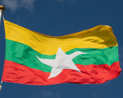 Amnesty International и Джо Фриман о восстановлении Мьянмы после землетрясения TheNationalFlagOfMyanmarFliesAgainstAClearBlue