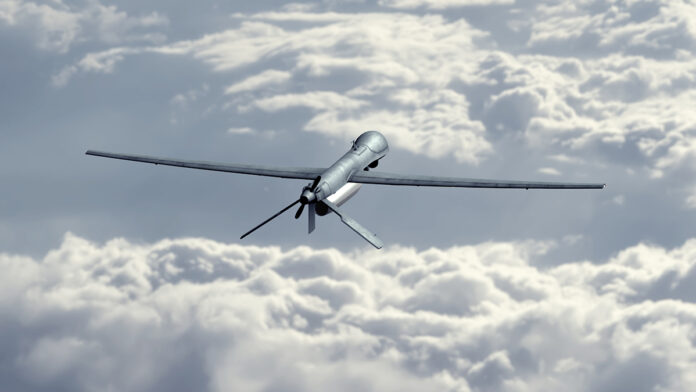 UnmannedMilitaryDroneFlyingInTheSkyAboveTheClouds