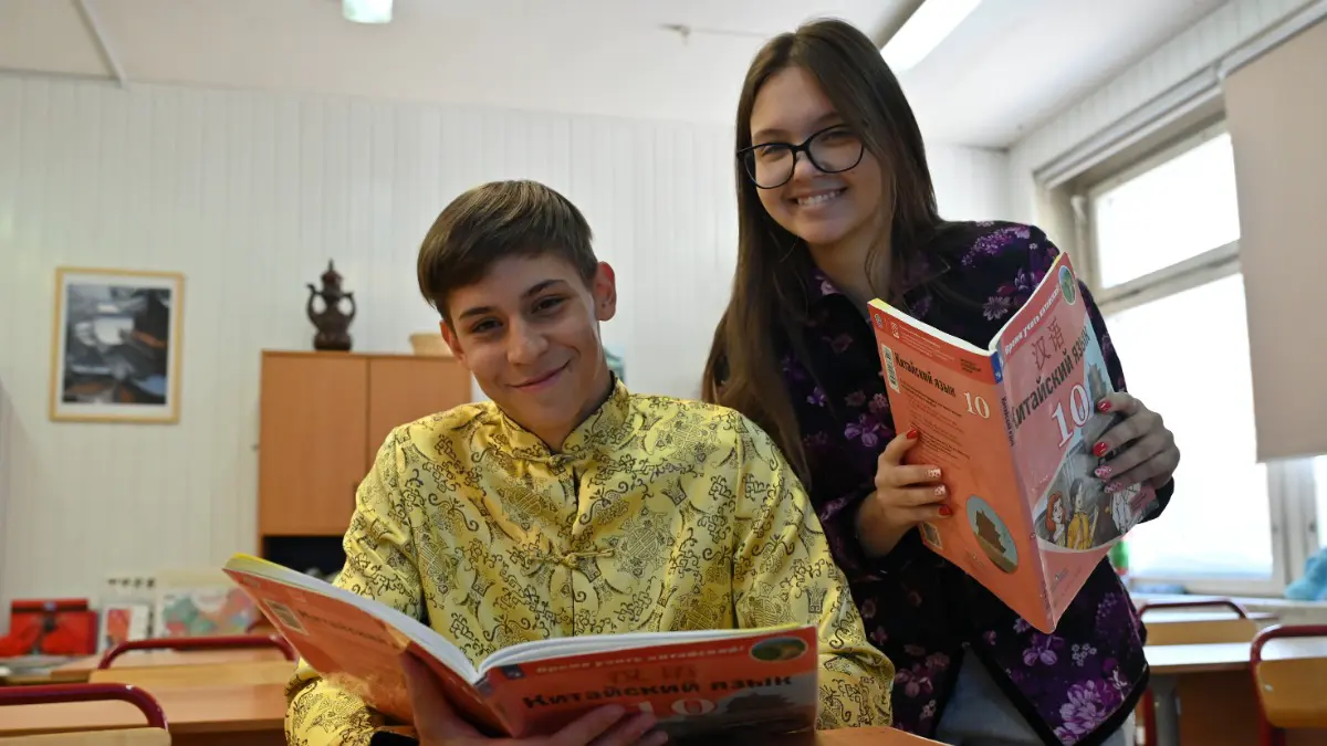 Ученики 10-го класса школы № 1948 Владимир Фомин и Александра Костоправкина с учебниками китайского языка, который они учат со второго класса