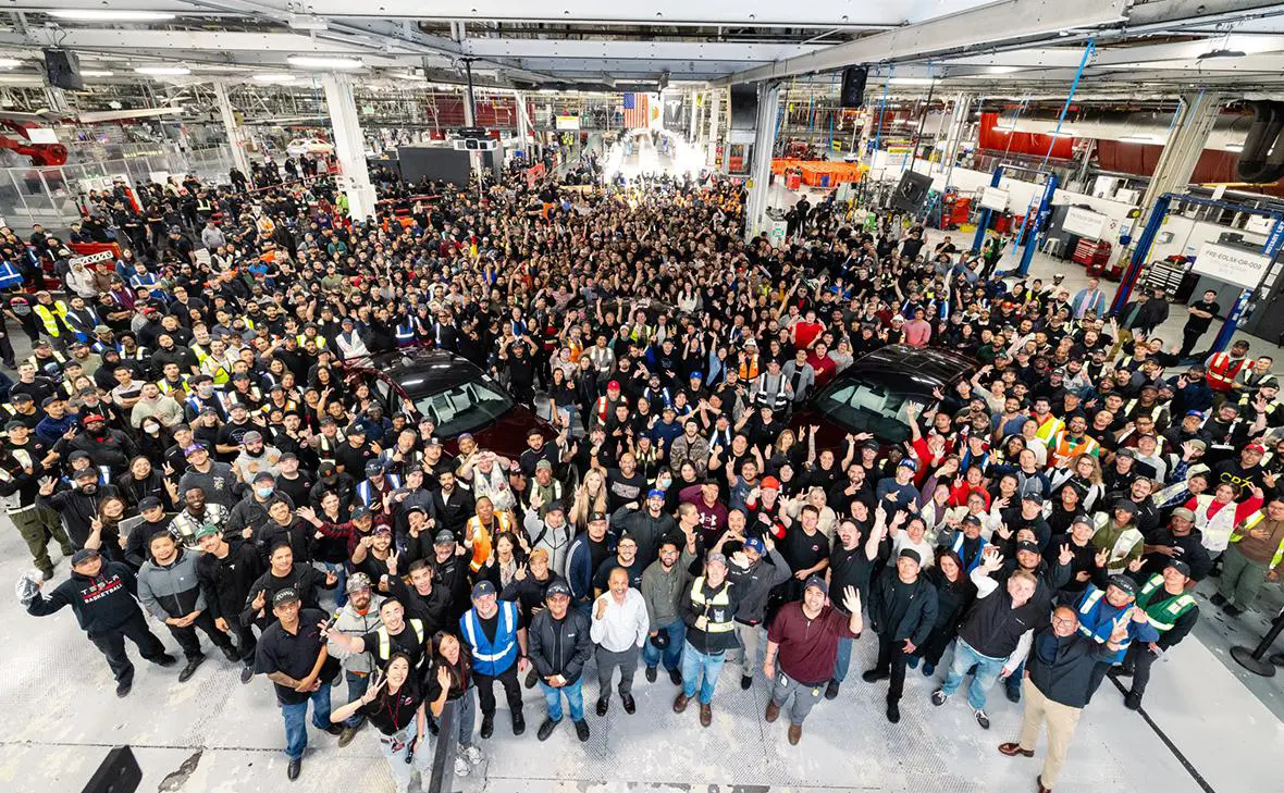 Работники позируют с последними автомобилями Model S и Model X (Tesla / X)