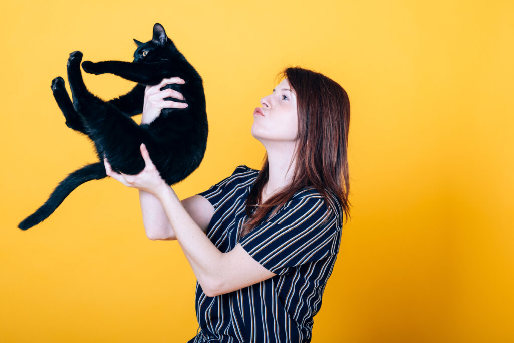 happy cheerful woman playing with a young black cat - tstpp женщина играет с черной кошкой