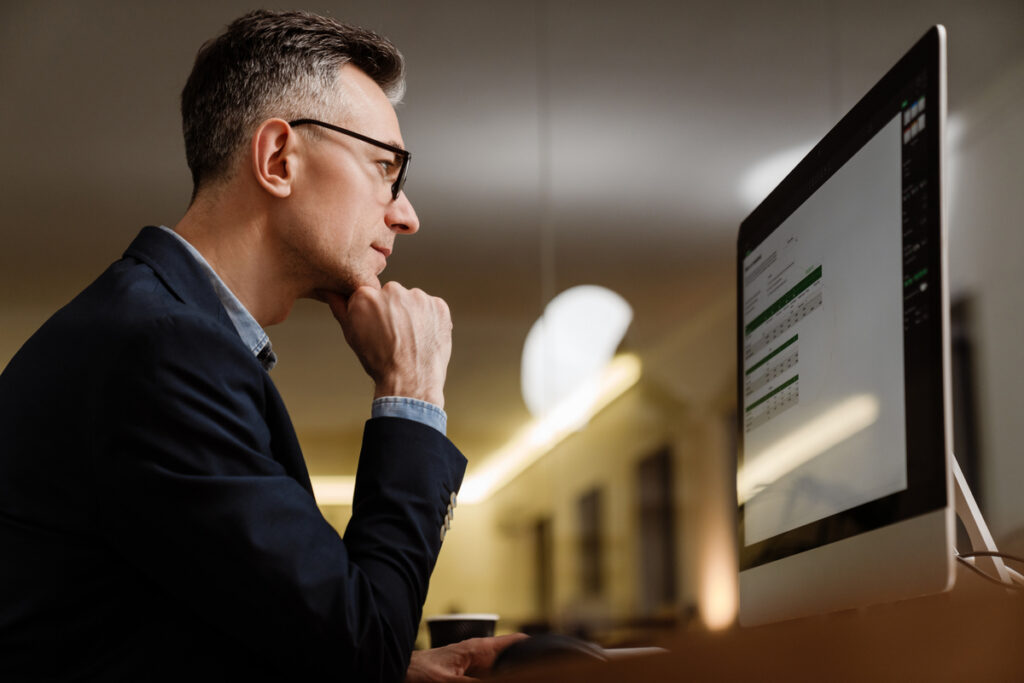 Серьезный мужчина работает за компьютером