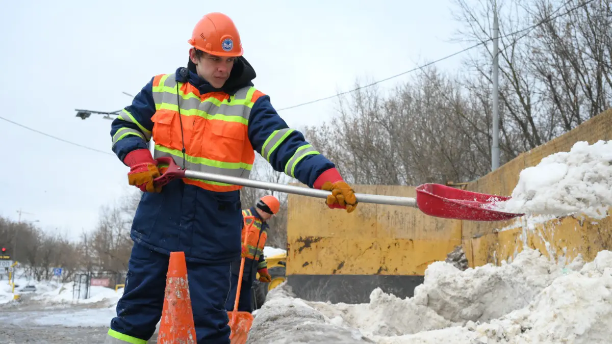 Рабочий Никита Буянов загружает снег на снегосплавном пункте