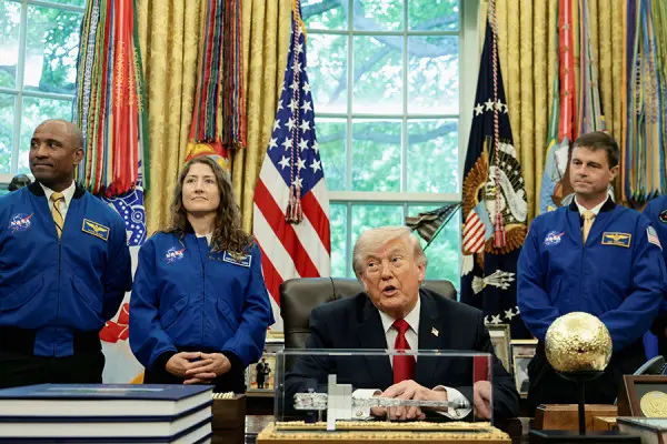 Командующий NASA Рид Уайзман, пилот Виктор Гловер и специалист миссии со стороны NASA Кристина Кох стоят за спиной президента США Дональда Трампа во время его выступления в Овальном кабинете  (Evelyn Hockstein / Reuters)