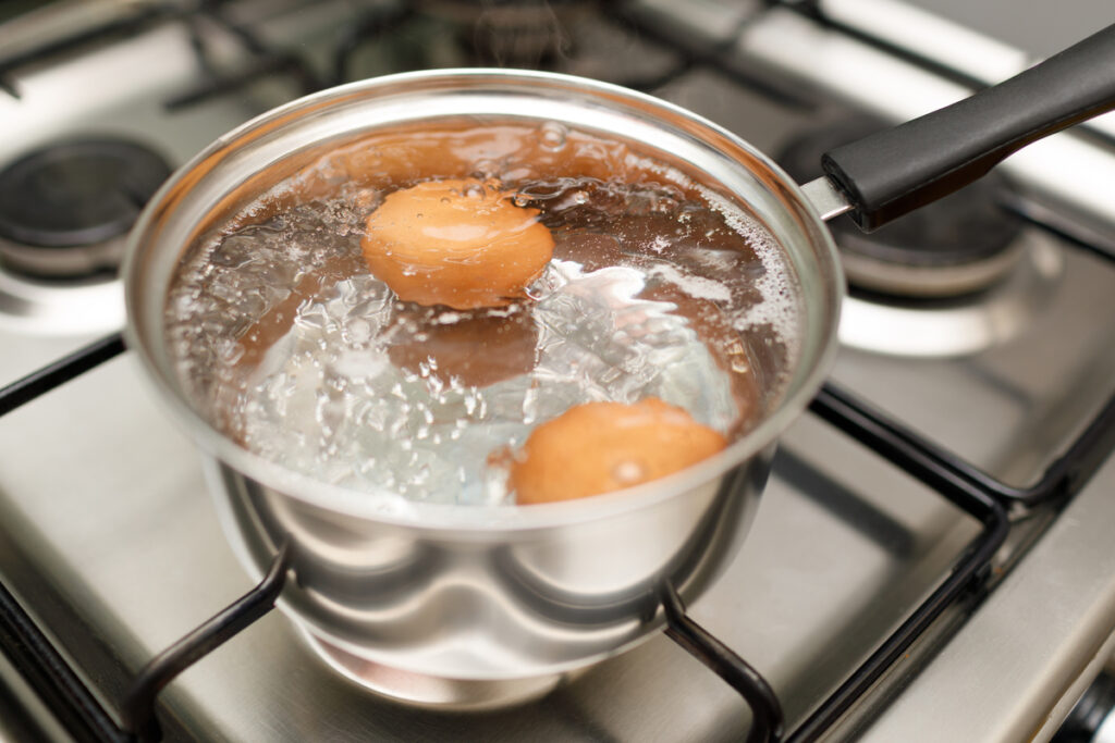 Saucepan stainless steel with boiling eggs breakfast in a water on a gas stove - infovzor Кастрюля с вареными яйцами