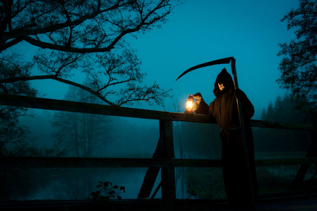 Man looks like death with scythe on old bridge - infovzor Смерть с косой на старом мосту