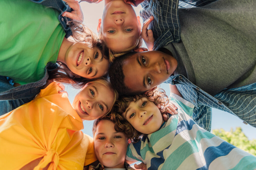 bottom view of happy multicultural kids looking at camera - infovzor Вид снизу на счастливых детей
