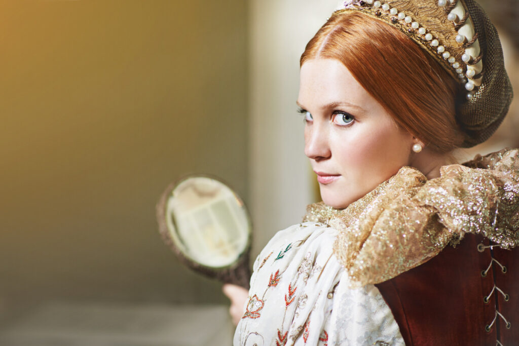 Shot of an elegant noble woman admiring herself in a mirror in her palace room - infovzor Знатная женщина, любующаяся собой в зеркале