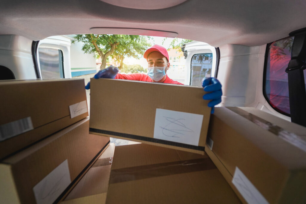 Курьер держит картонную коробку для доставки