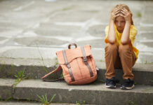 Как вернуть детям желание учиться? Грустная маленькая школьница сидит на лестнице на улице