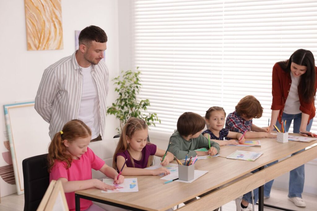 Дети с учителями на уроке рисования