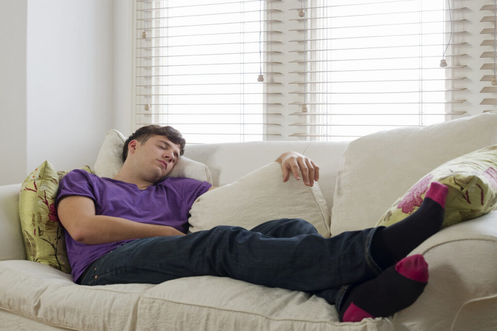 Молодой человек спит на диване