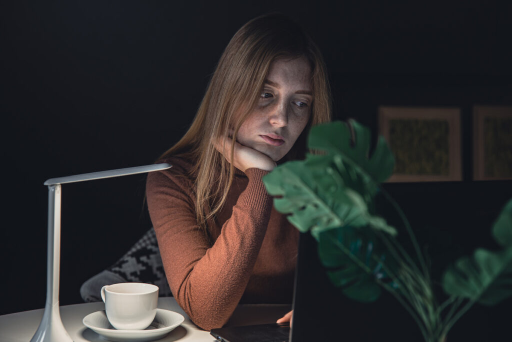 Женщина работает ночью за ноутбуком
