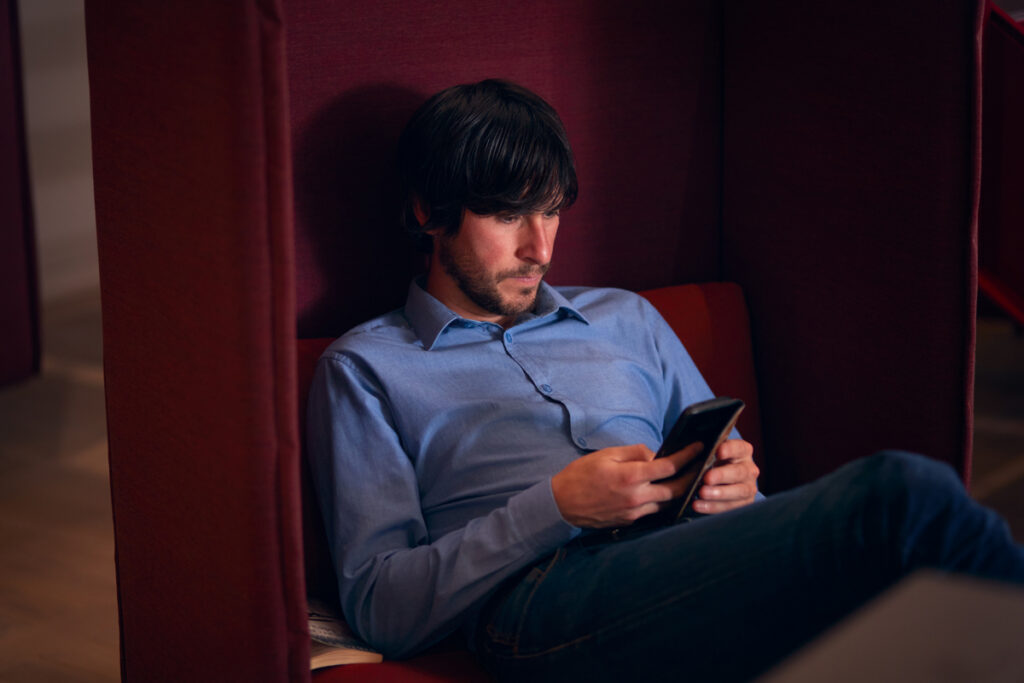 Бизнесмен проверяет сообщения на мобильном телефоне