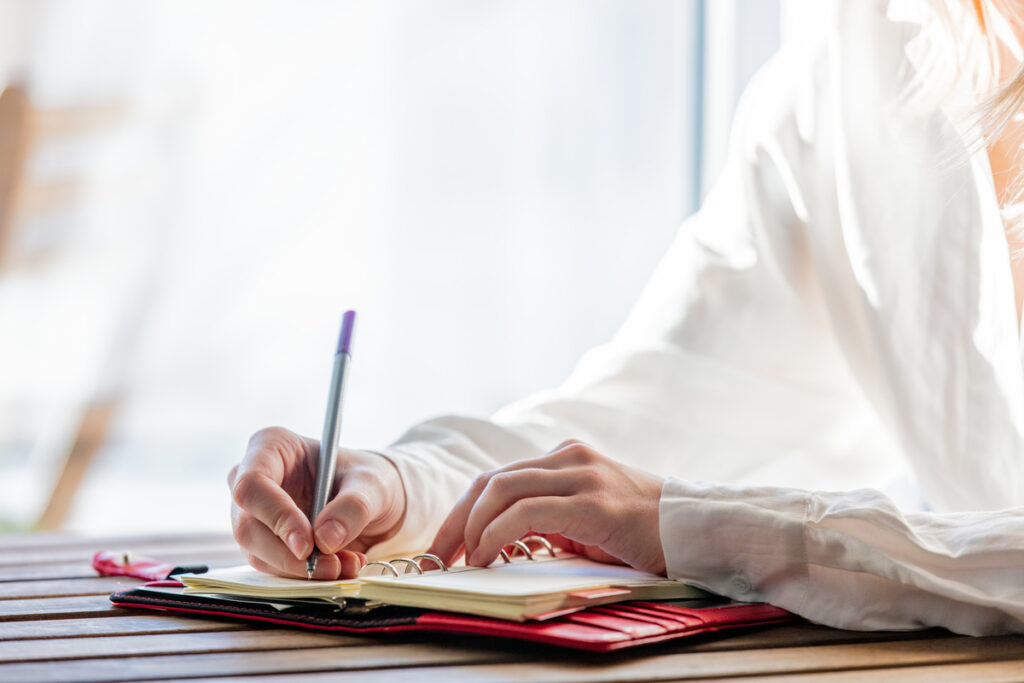 Девушка пишет в блокноте