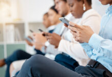 Люди сидят в телефоне на совещании