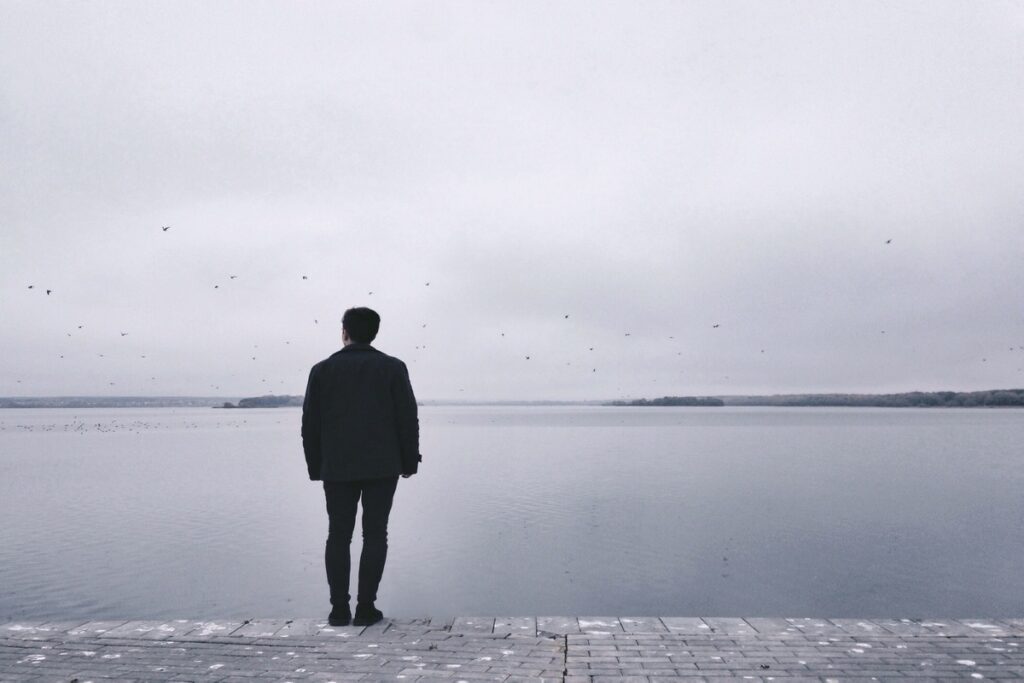 Мужчина стоит у воды