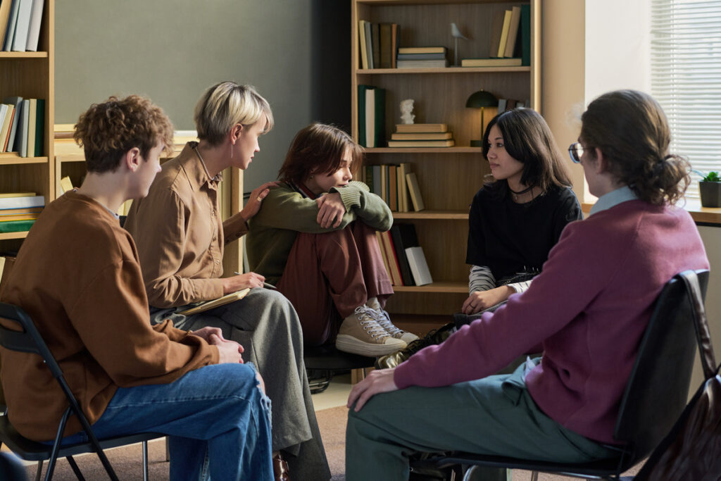 Молодые люди поддерживают друг друга во время сеанса групповой терапии