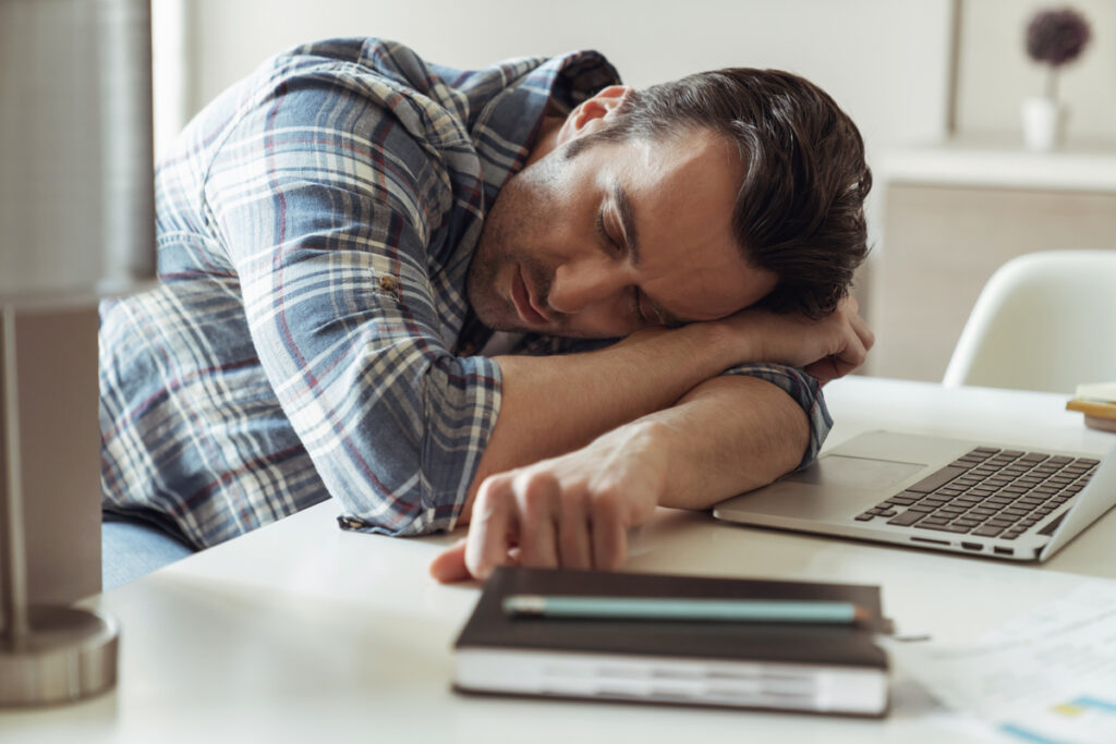Мужчина дремлет за ноутбуком
