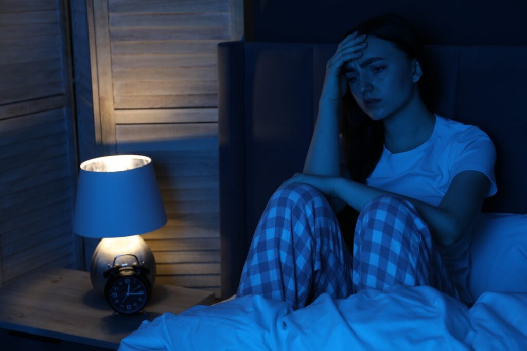 Разочарованная девушка, страдающая бессонницей в постели