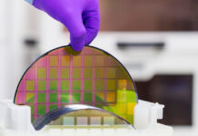 Silicon Wafer with semiconductors in plastic white storage box take out by hand in gloves inside clean room