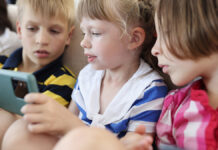 Цифровые технологии и развитие речи современных детей ThreeChildrenAreSittingOnTheCouchAndLookingAt