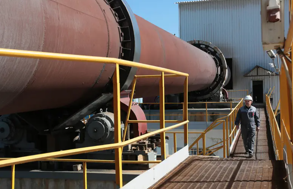 Мужчина в рабочей форме идет по производству