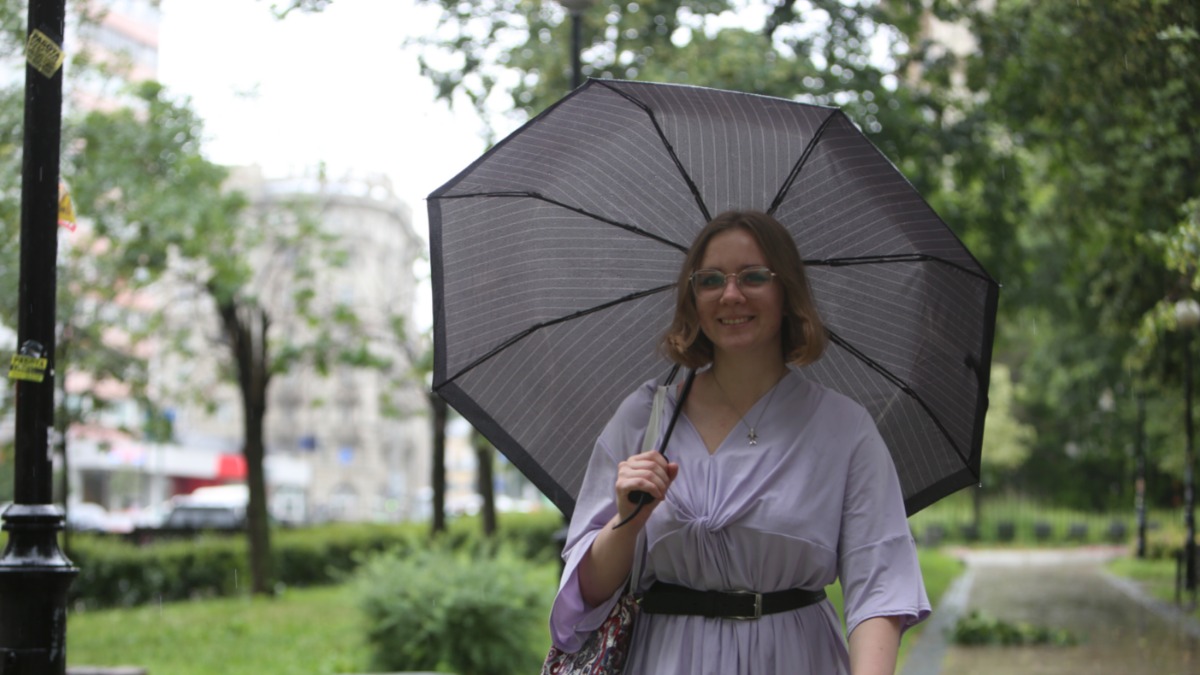 Москвичка Мария Кохан пережидает ливень у станции метро «Чкаловская»