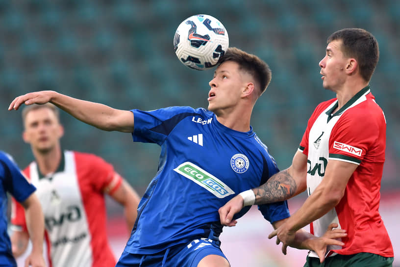 Игроки «Локомотива» (Москва) Дмитрий Воробьев (справа) и «Оренбурга» Данила Прохин (в центре) во время матча Российской премьер-лиги по футболу в Москве