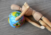 Странные решения глобальных проблем Wooden human figure holding globe planet Earth world economic crisis