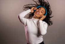 Музыканты научно управляют вашими эмоциями Девушка веселится, улыбается, танцует в наушниках