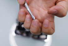 Мужчина очищает ноготь