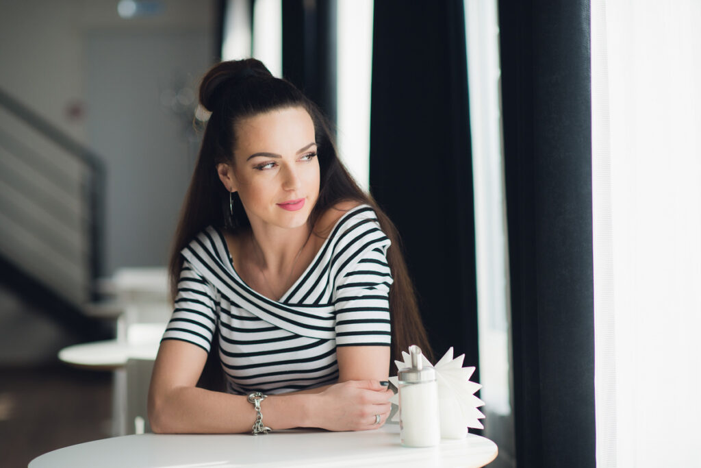 Одинокая красивая женщина в кафе