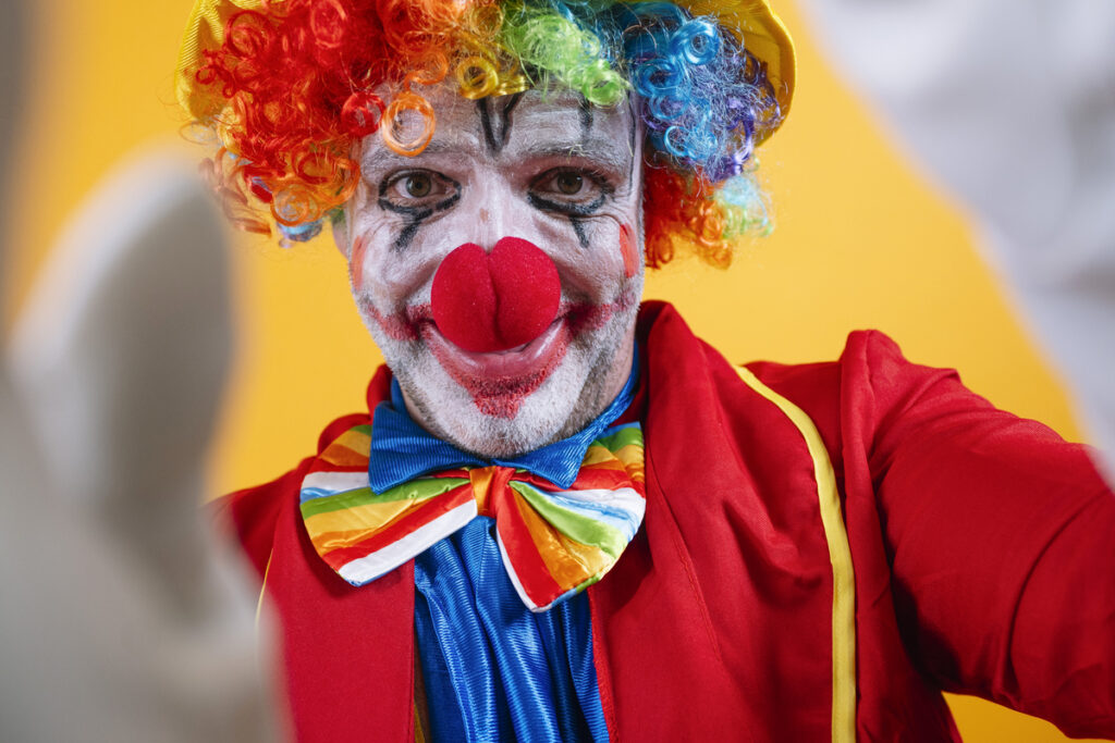 Счастливый клоун в красочном костюме