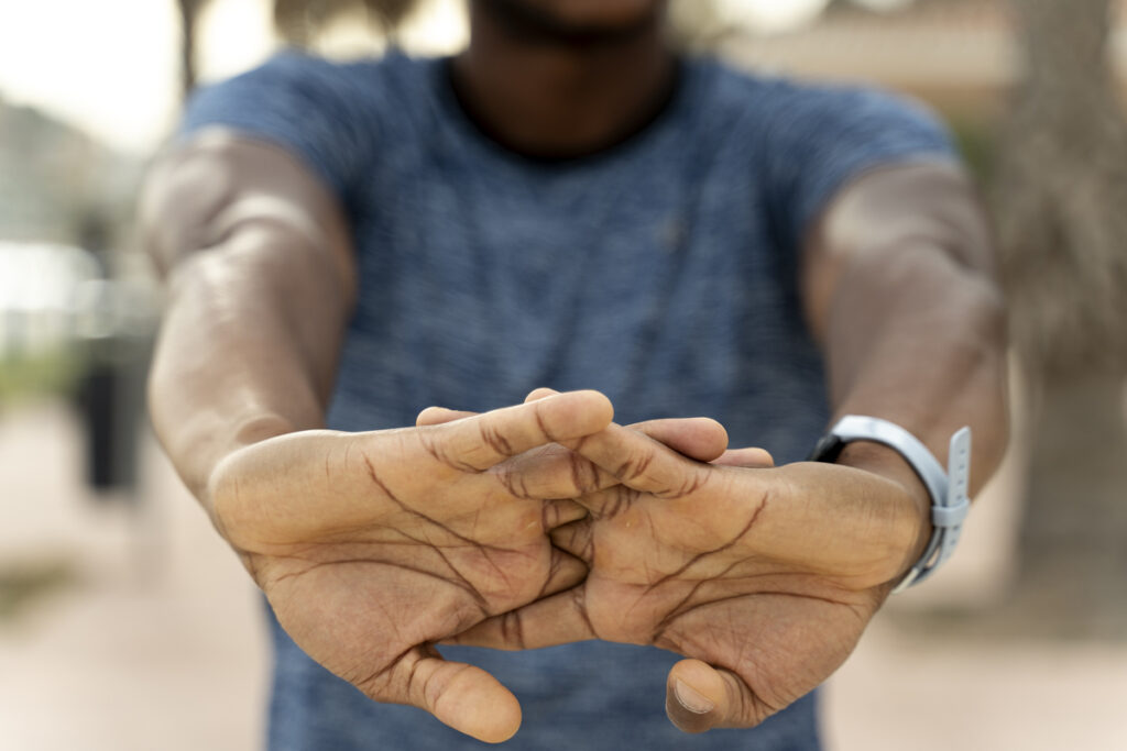 спортсмен разминает руки