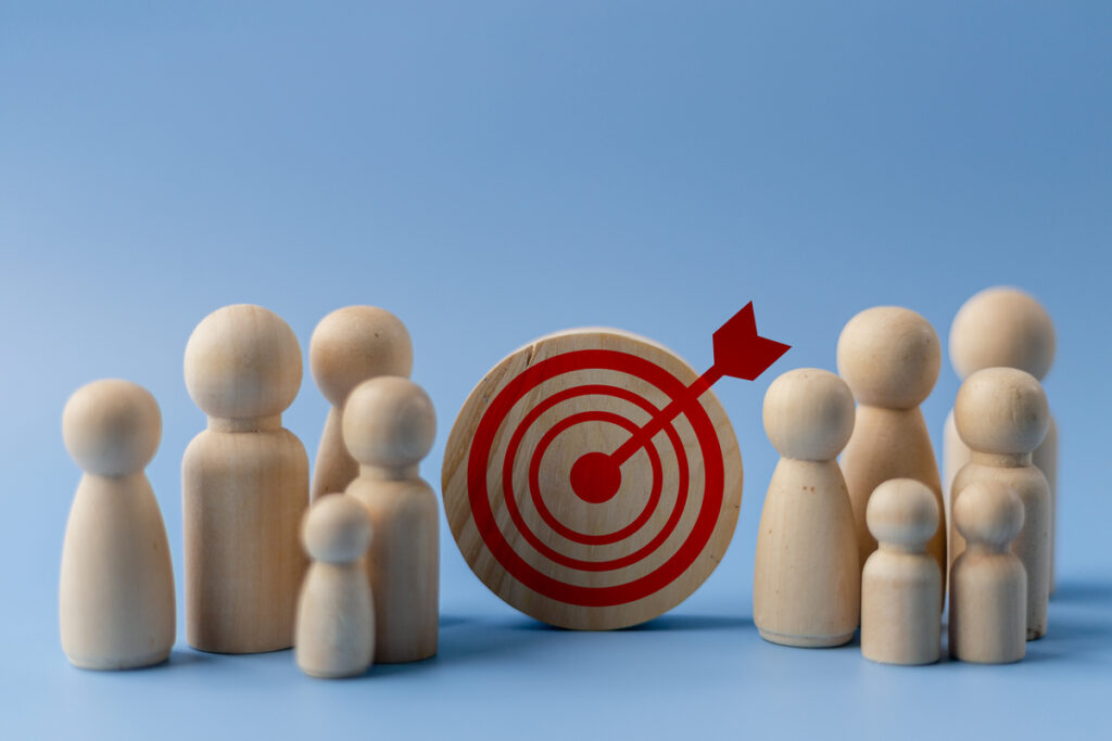 Деревянные фигурки людей и мишень на синем фоне