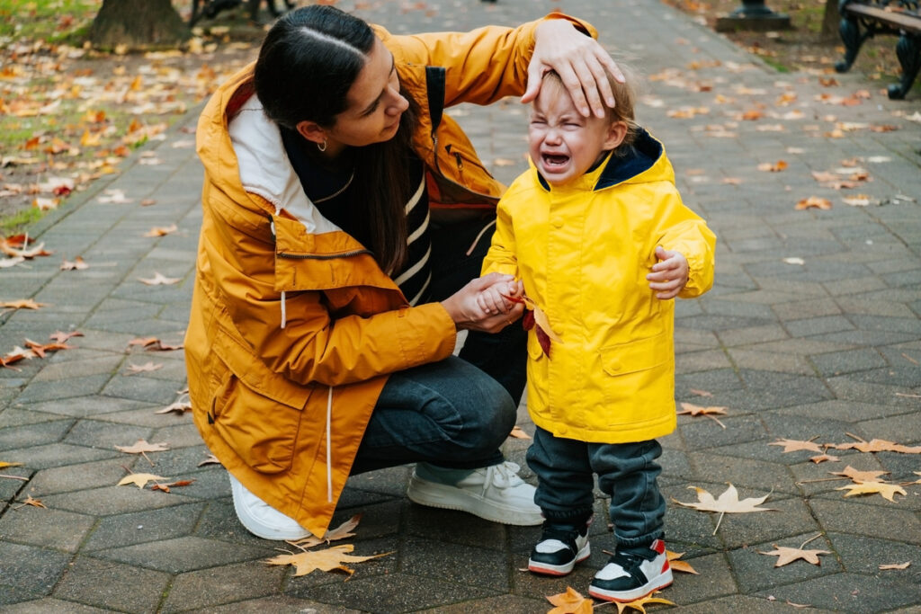 Молодая мать пытается успокоить плачущего сына