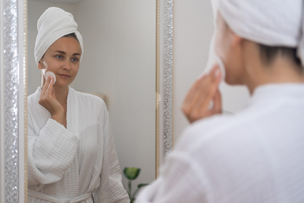 Молодая женщина наносит средство на лицо