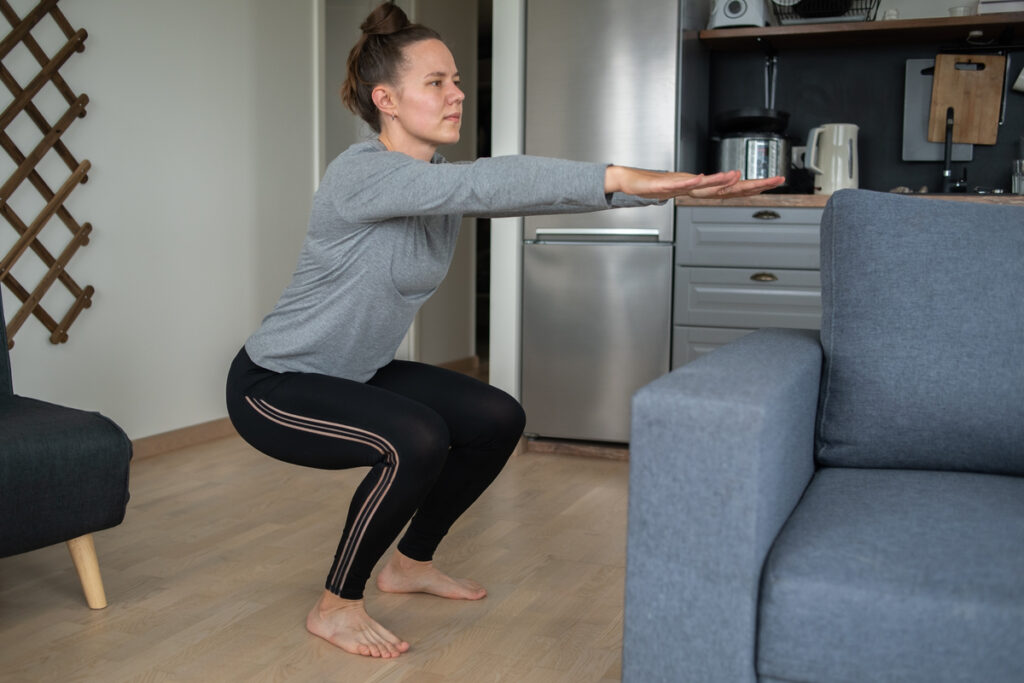 Женщина занимается фитнесом дома