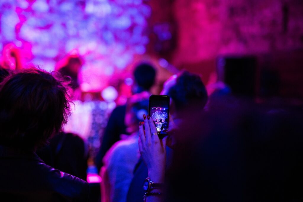 Человек снимает праздник на телефон