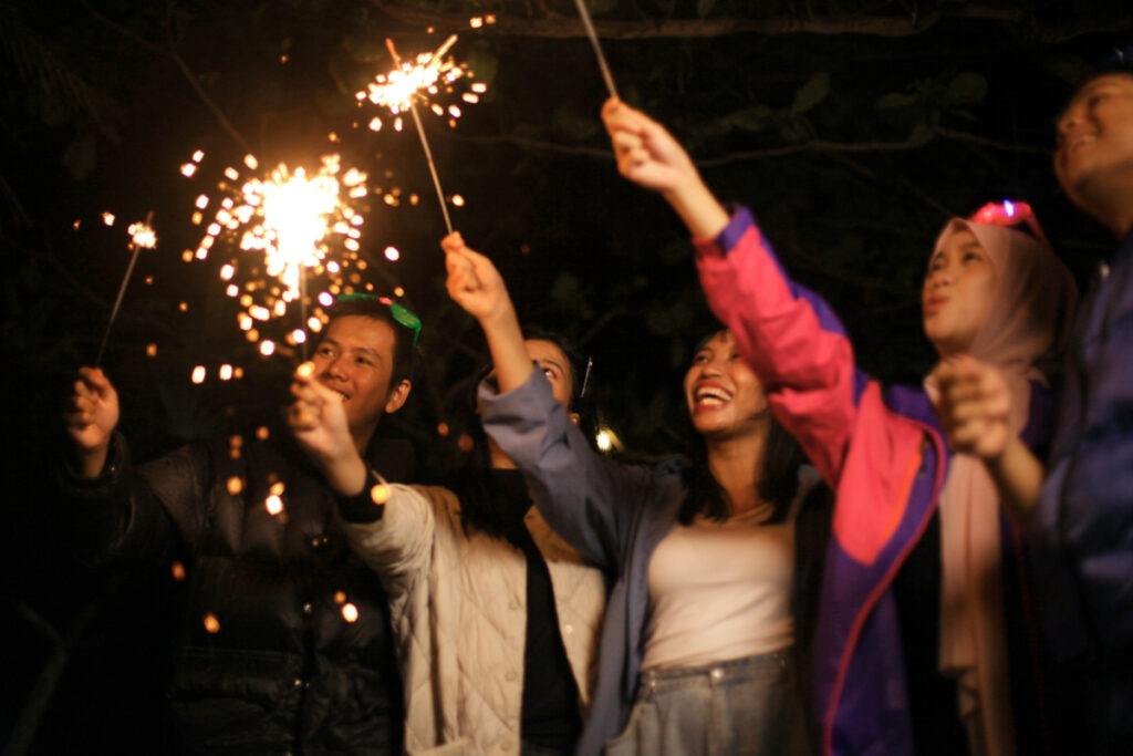 Люди празднуют с бенгальскими огнями