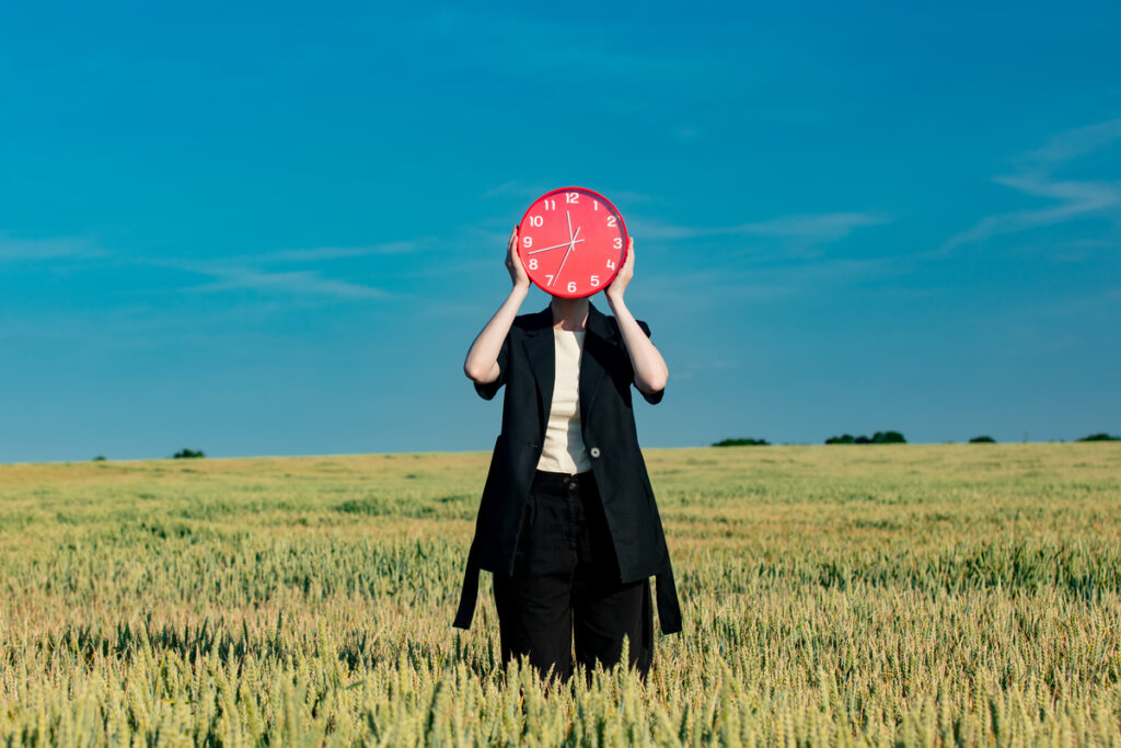 Бизнесвумен с часами на пшеничном поле