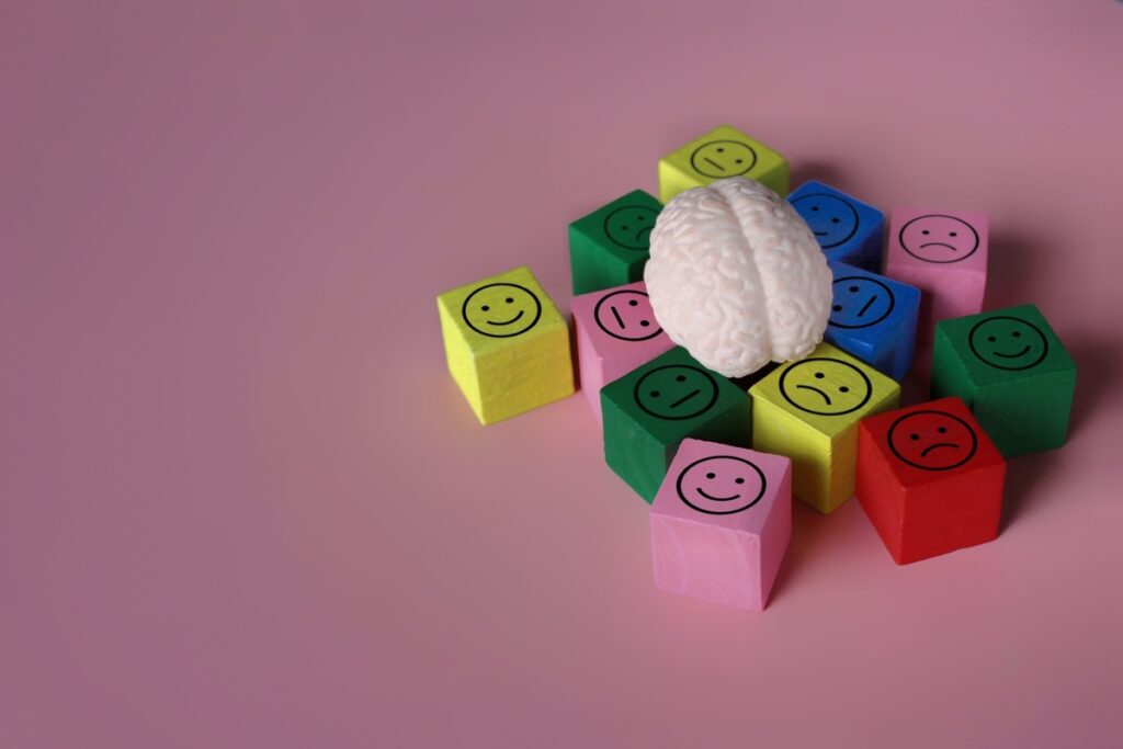 Человеческий мозг с иконкой счастья, нейтральности и грусти