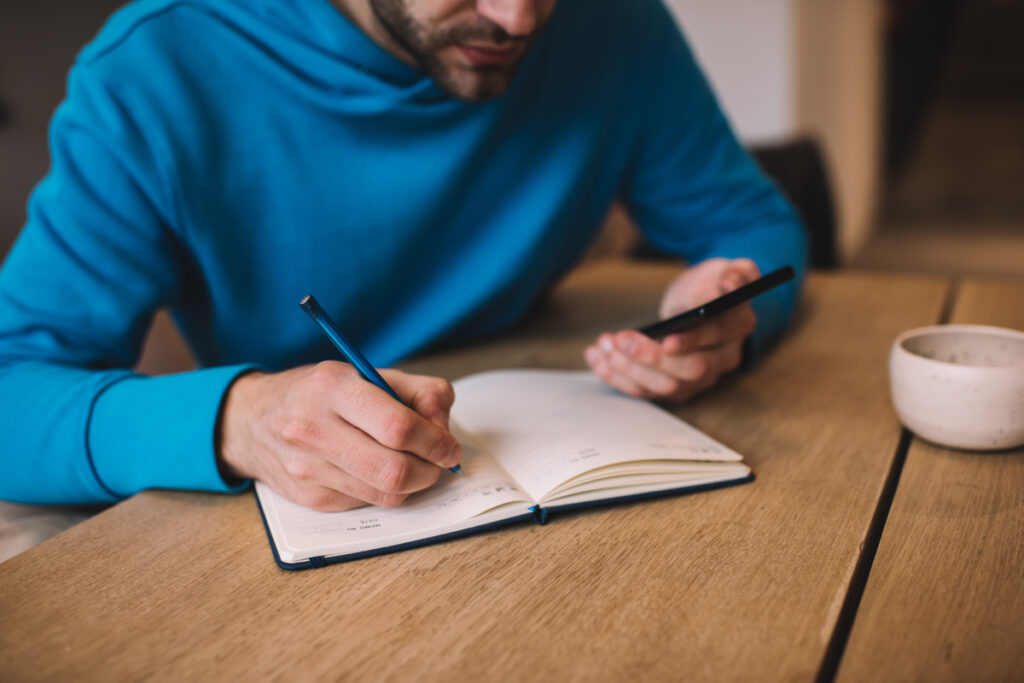 Мужчина пишет в дневнике