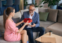 Как выбрать подарок на 23 февраля? Мужчина принимает подарочную коробку от женщины