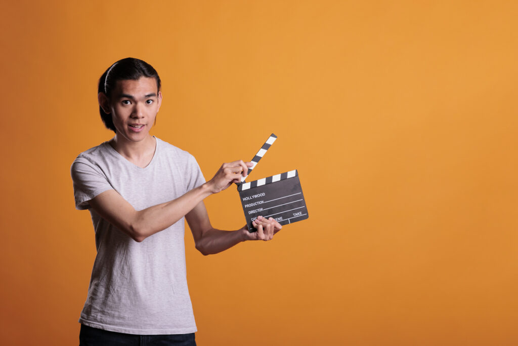 Мужчина держит хлопушку для кино