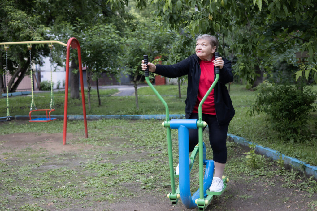 Пожилая женщина занимается на эллиптическом тренажере
