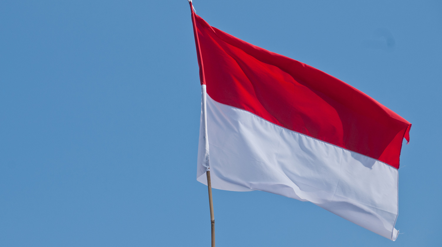 White and Red national flag of Indonesia with blue sky