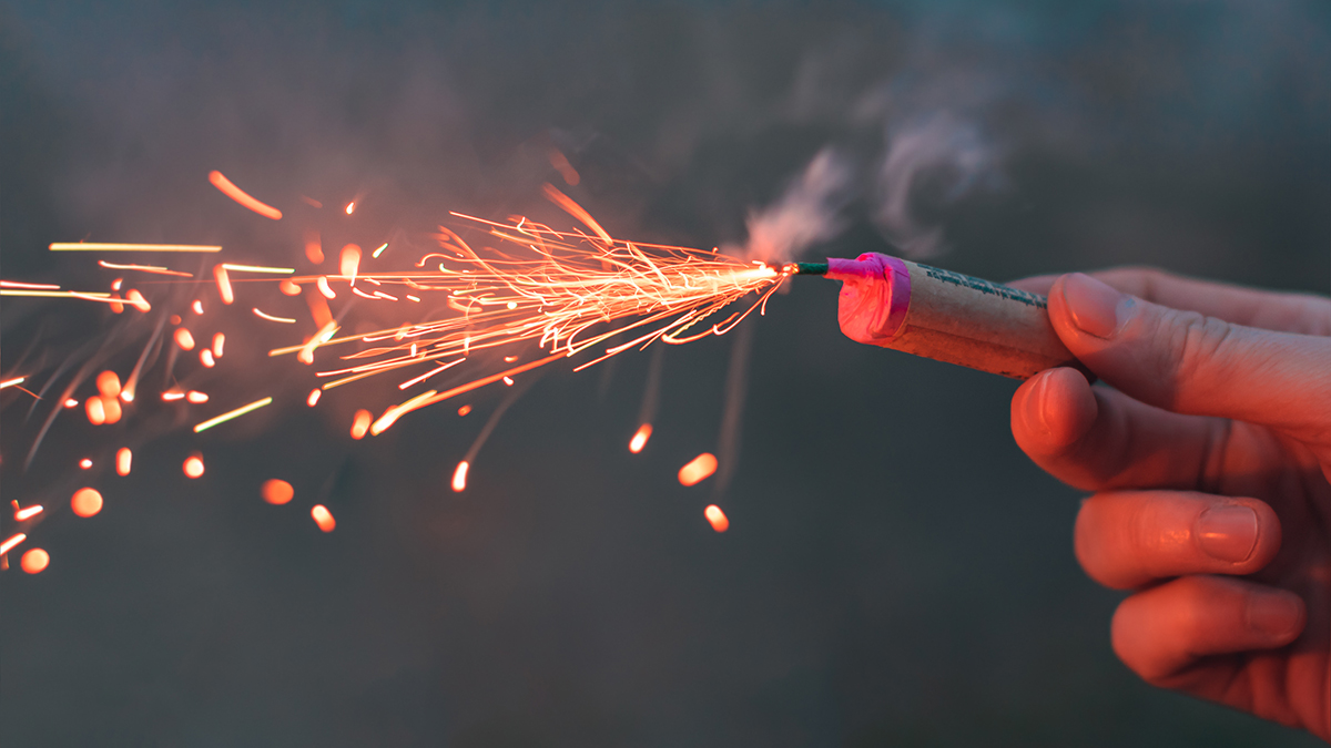Young,Man,Lighting,Up,Firecracker,In,His,Hand,Outdoors,In