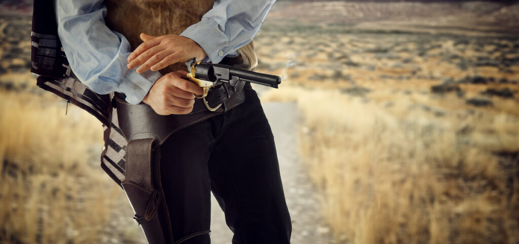 ковбой готовится стрелять из пистолета